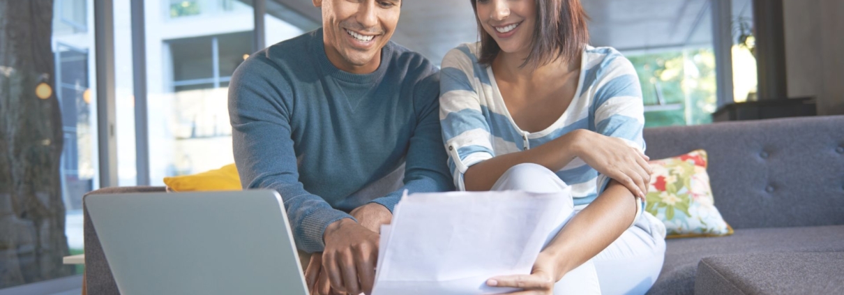 Una pareja evaluando archivos y sonriendo