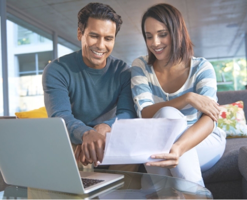 Una pareja evaluando archivos y sonriendo