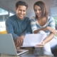 Una pareja evaluando archivos y sonriendo